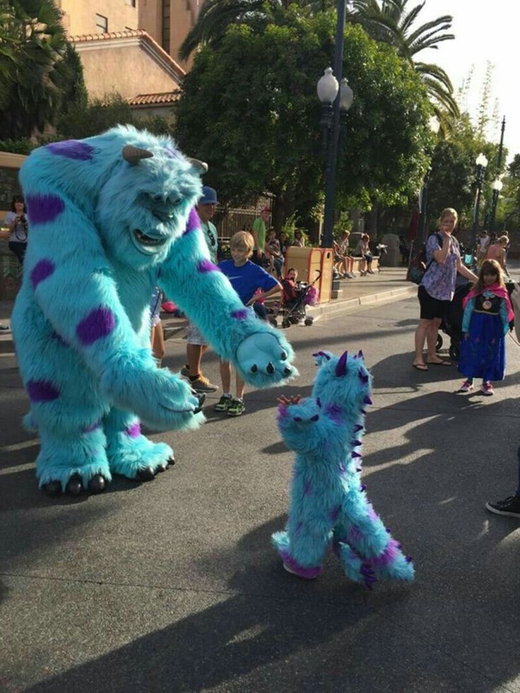 people in costumes are walking down the street with one person dressed as a monster and the other as a dog