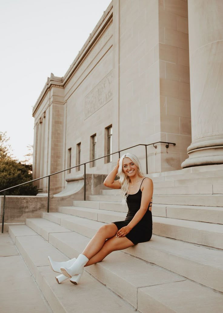 a woman sitting on steps in front of a building