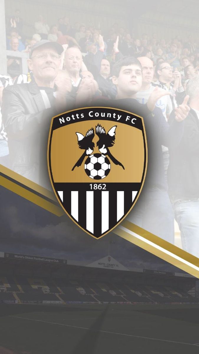 a group of people standing next to each other in front of a soccer field with the words notts countyfc on it