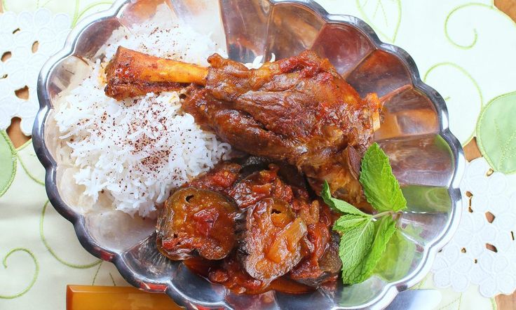 a bowl filled with meat and rice on top of a table