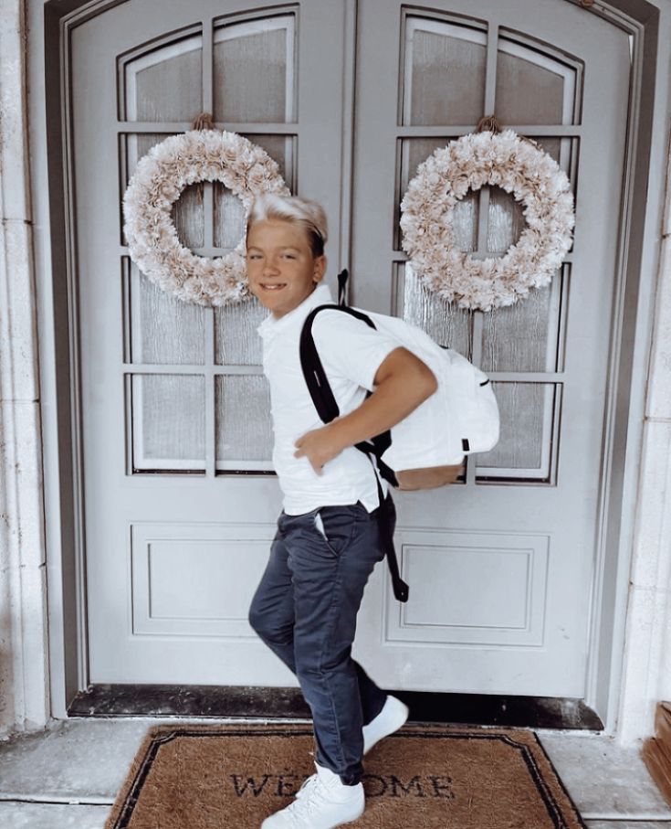 a young boy standing in front of a door