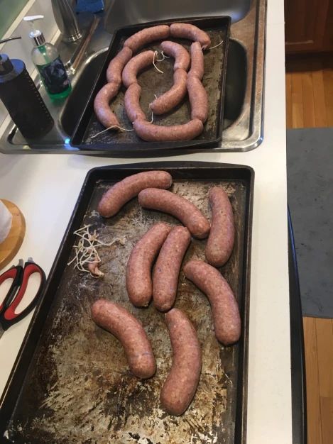 two pans filled with cooked sausages sitting on top of a counter next to each other