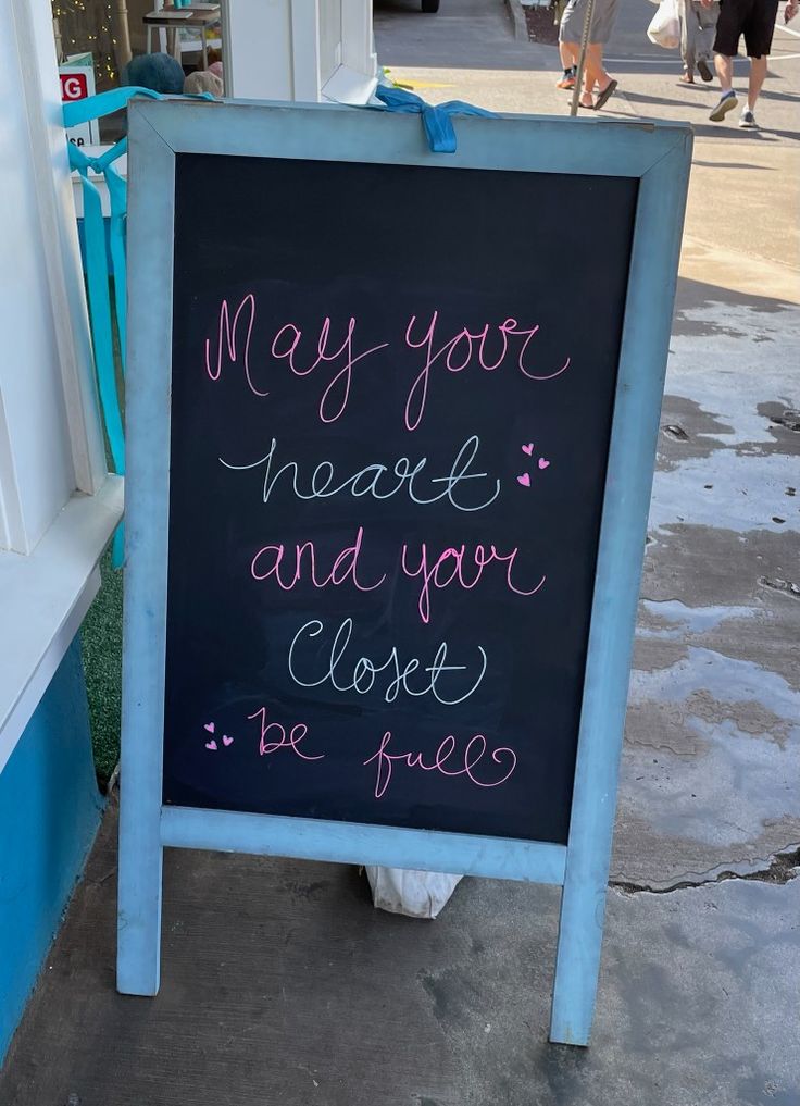 a chalkboard sign that says may you have and your closet be free? on the sidewalk