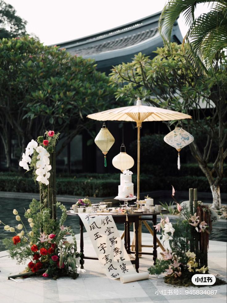 a table with an umbrella and flowers on it