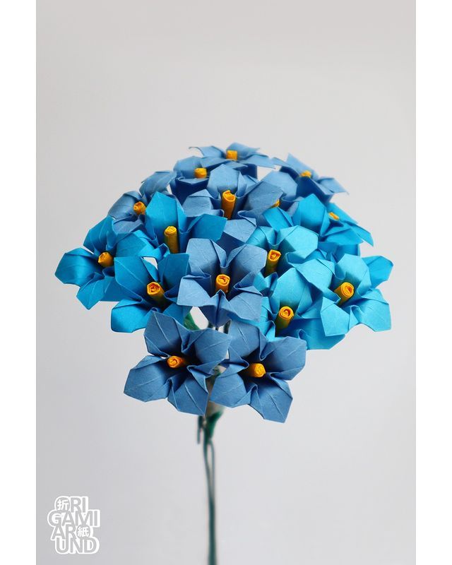 blue flowers are in a glass vase on a table