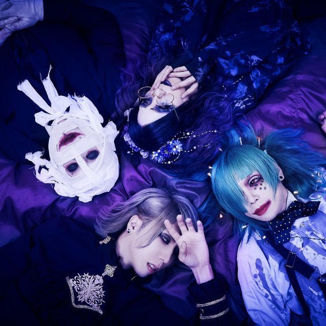 three women with blue hair and white masks on their heads are laying in a bed