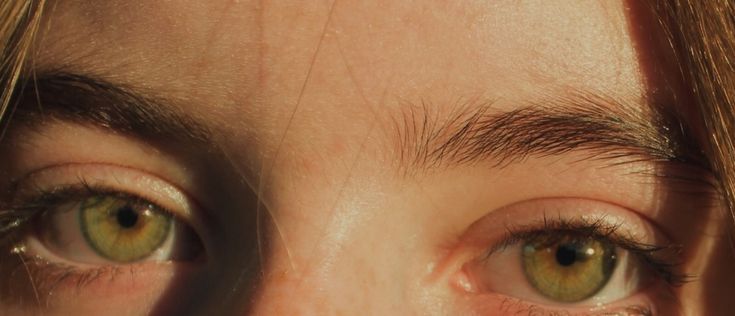 a woman's green eyes with long hair