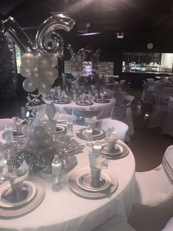 the tables are set with silver and white decorations