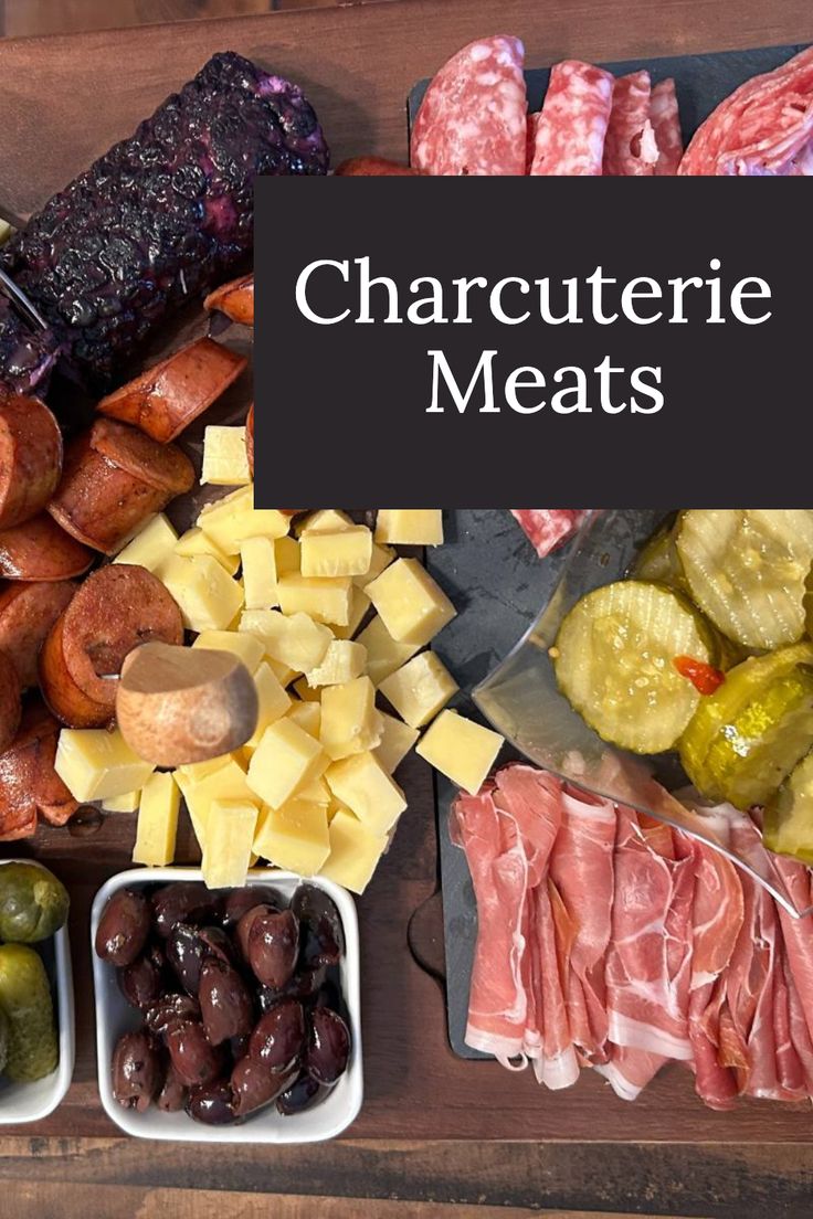 an assortment of charcuterie meats and olives on a cutting board