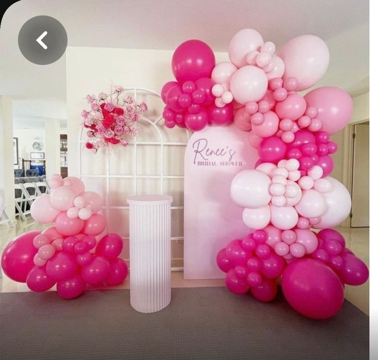 pink and white balloons are on display in a room