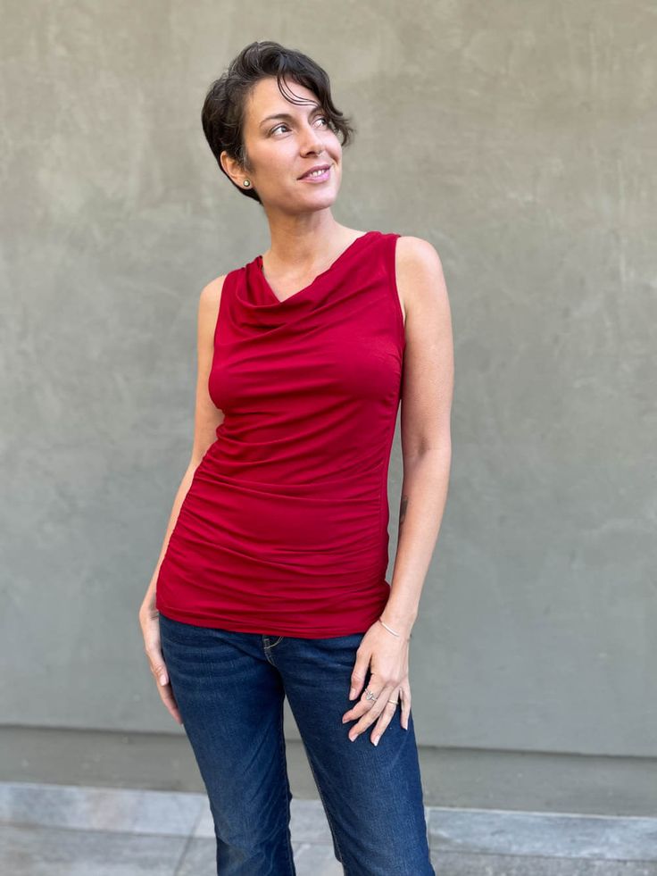 women's plant based rayon jersey red top with ruching on sides and slight cowl neck #color_red Solid Color Tops With Ruched Sides And Stretch, Asymmetrical Neckline Stretch Tops, Versatile Stretch Top With Asymmetrical Neckline, Versatile Stretch Tops With Asymmetrical Neckline, Versatile Tops With Asymmetrical Neckline And Stretch, Fitted Ruched Tops For Layering, Chic Draped Elastane Tops, Versatile Fitted Draped Top, Fitted Top With Ruched Sides