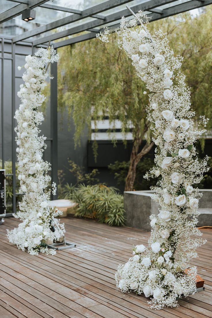 an outdoor ceremony with white flowers and greenery