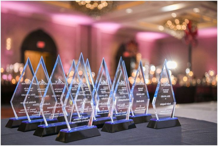 four clear trophies sitting on top of a table