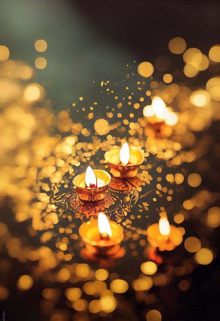 many lit candles floating on top of a water covered surface with blurry lights in the background