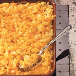 a pan filled with macaroni and cheese next to a spoon