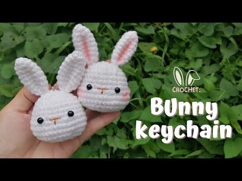 two crocheted bunny keychains are shown in front of some green plants