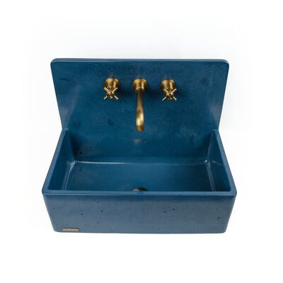 a blue sink with two golden faucets on the front and bottom, against a white background