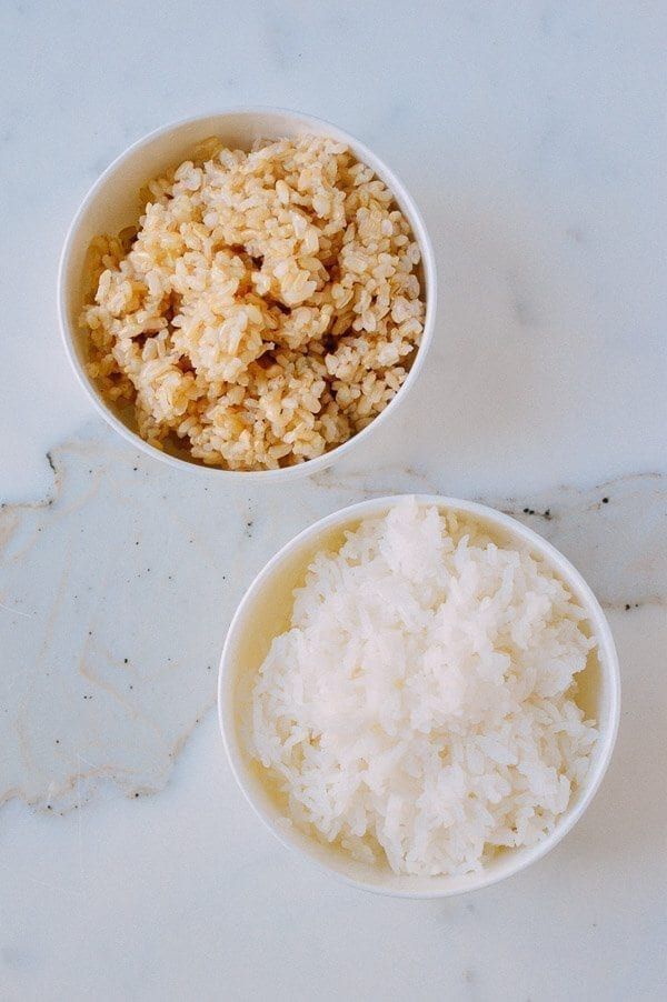 two bowls filled with rice sitting on top of a white marble counter next to each other