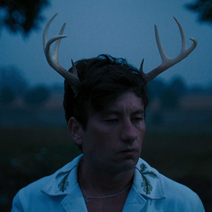 a man with antlers on his head in the dark