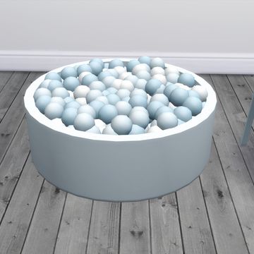 a large bowl filled with lots of balls on top of a wooden floor next to a chair