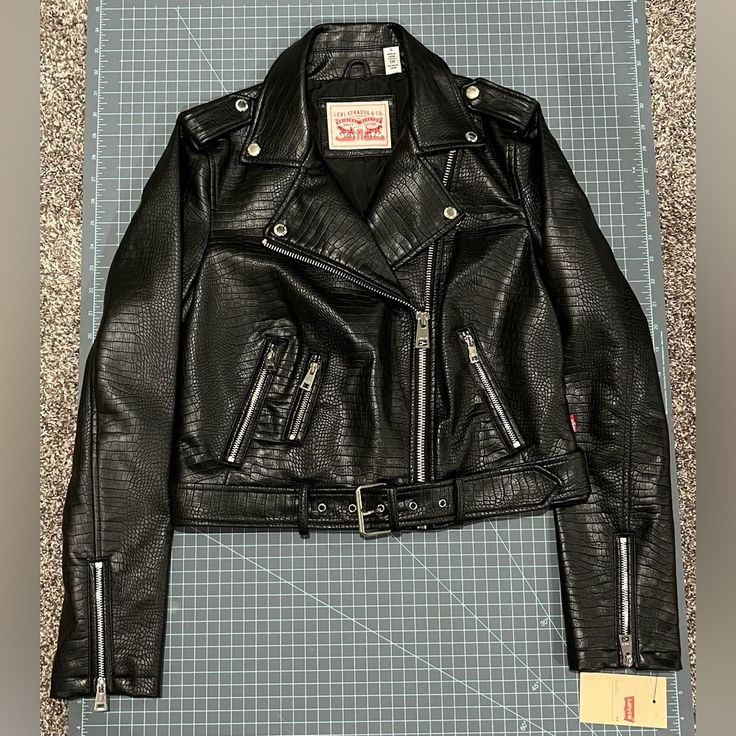 Levi’s Black Croc Faux Leather Moto Jacket With Removable Belt. Size Small. Crocodile Textured Pattern Throughout Entire Jacket. Lined. Black With Silver Hardware. Three Zippered Pockets: Two Normal Sized Pockets And One Small One. Zippers On Sleeves. Snaps To Keep Lapels Down. New With Tags. Never Worn Levi's Black Leather Jacket For Fall, Levi's Black Winter Biker Jacket, Levi's Fitted Biker Leather Jacket, Retro Black Biker Jacket With Zipper Closure, Levi's Black Outerwear With Zipper Closure, Levi's Biker Leather Jacket, Levi's Biker Leather Jacket With Zipper, Levi's Leather Biker Jacket With Zipper Closure, Levis Jacket