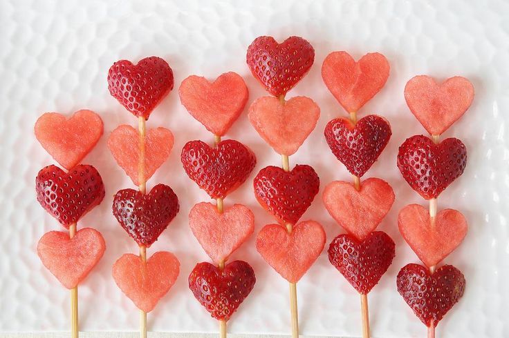 strawberries arranged in the shape of hearts on a stick