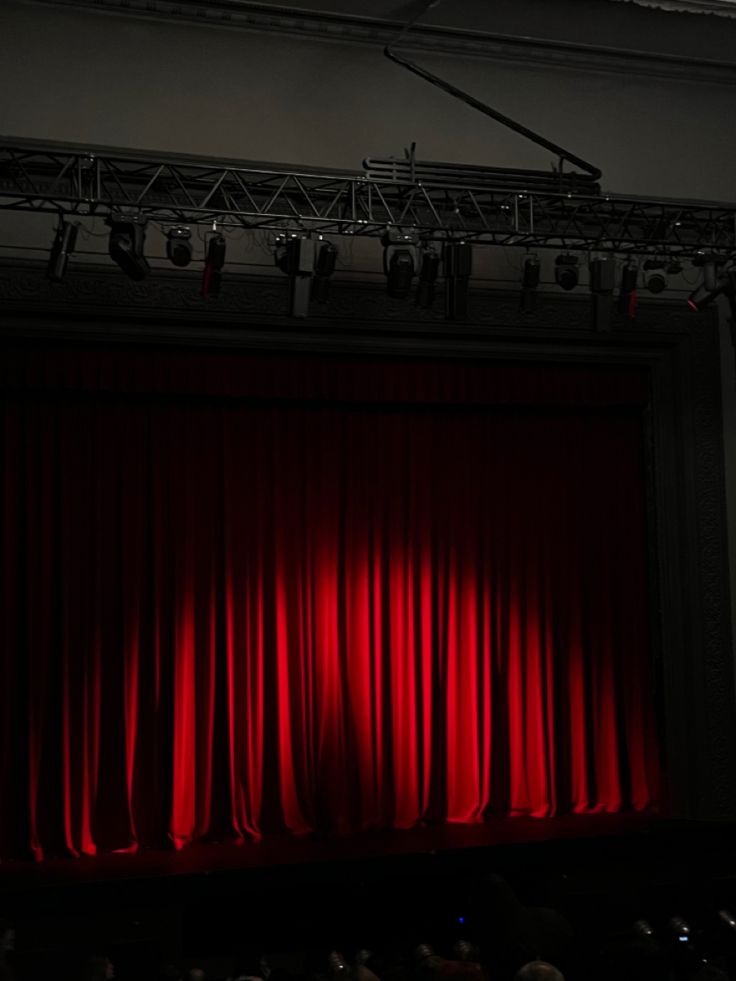 a stage with red curtains and spotlights