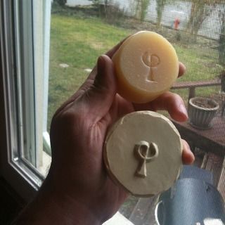 a person holding a piece of wax with a key on it in front of a window