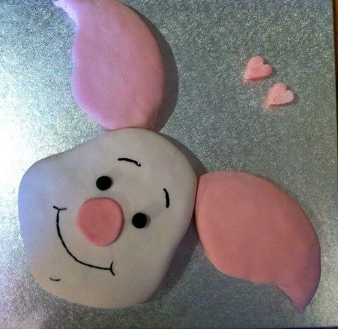 there is a frosted cake shaped like a tooth with pink ears on it's head