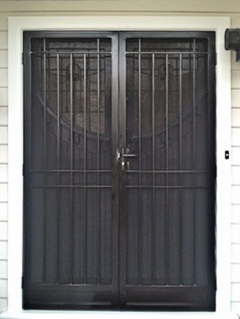 two black doors with bars on them in front of a white wall and door frame