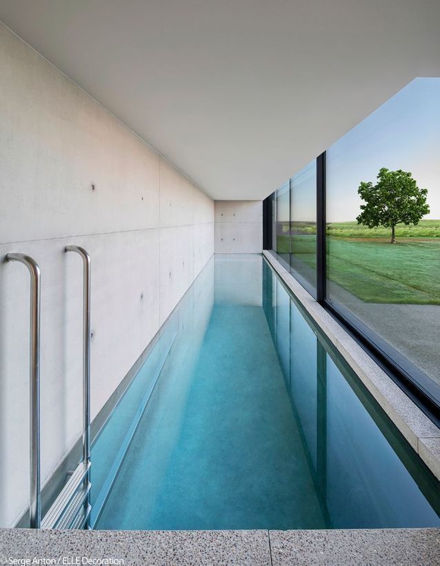 an empty swimming pool in front of a large window