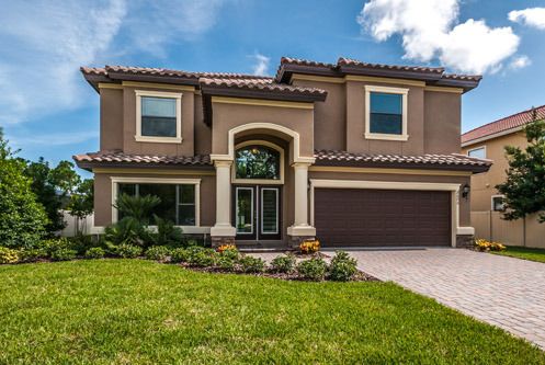 a house with a driveway in front of it and landscaping around the entrance to the home