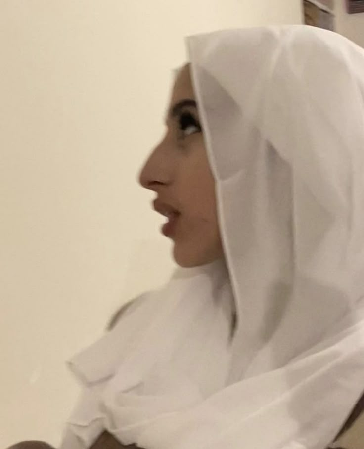 a woman wearing a white veil and holding a cell phone