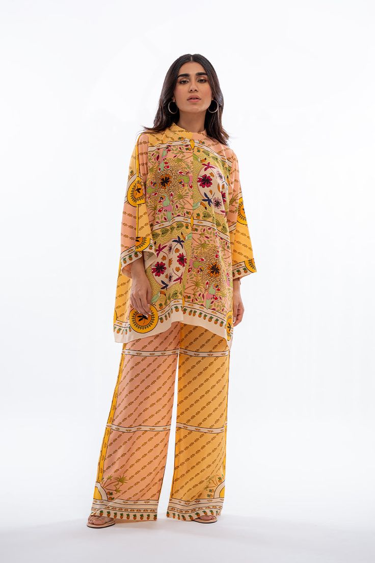 A playful fusion of colours and print takes centre stage in this mango yellow and peach co-ord set featuring a front open shirt and culottes.