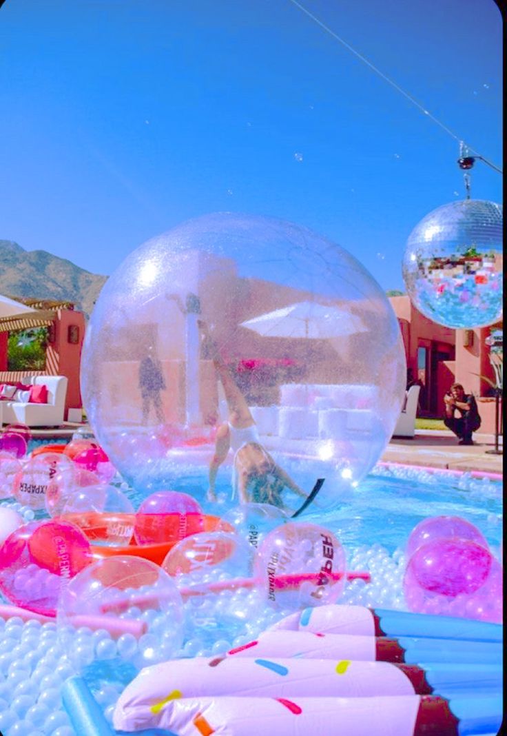 an inflatable ball floating on top of a pool filled with water and toys