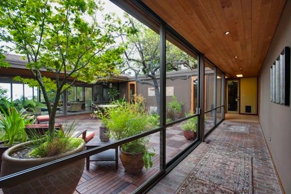 an outdoor patio with potted plants and large windows