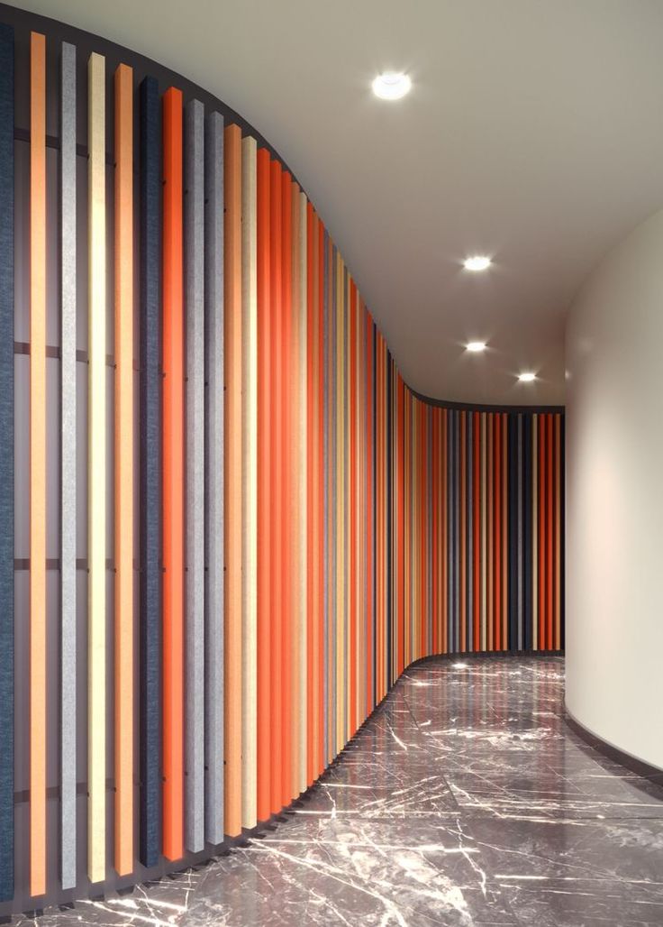 an orange and grey striped wall next to a white round room with marble flooring