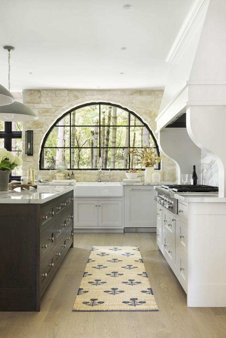 Kitchen with large stone accent wall above the sink. To the left sits an island and on the right is an stove and large white hood. Breakfast Nook Banquette, Bria Hammel Interiors, Bria Hammel, Cambria Countertops, Stone Accent Walls, Minnesota Home, Block Printed Pillows, Traditional Fireplace, Interior Windows