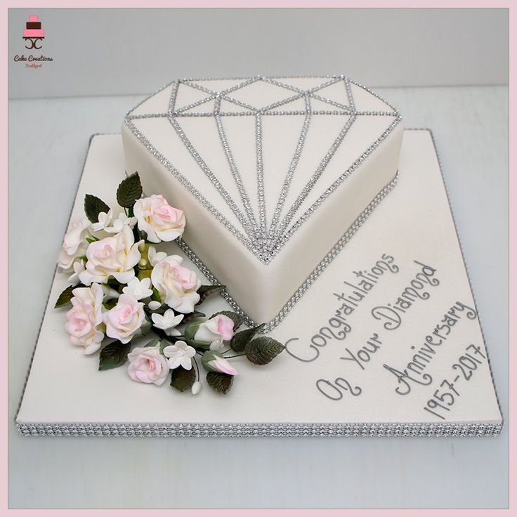 a birthday cake with flowers and a diamond on it