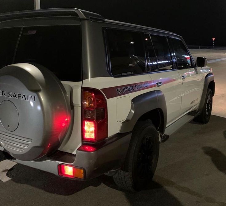 an suv parked in a parking lot at night with its rear lights turned on and the tail light showing