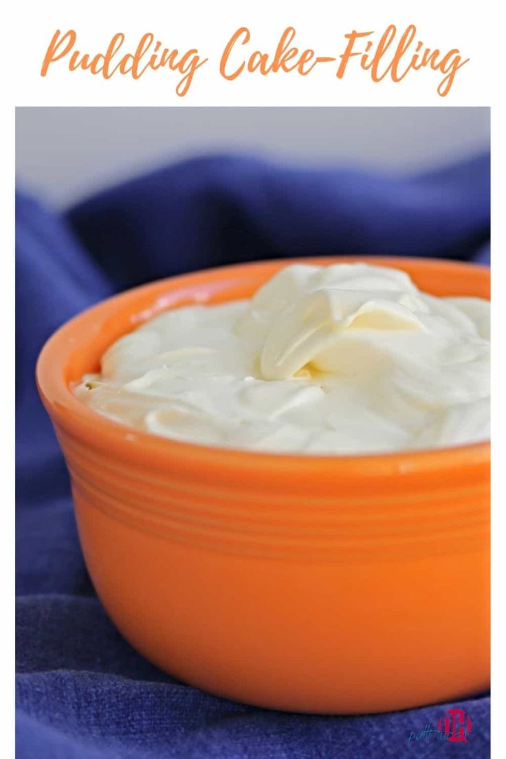 an orange bowl filled with whipped cream on top of a blue cloth