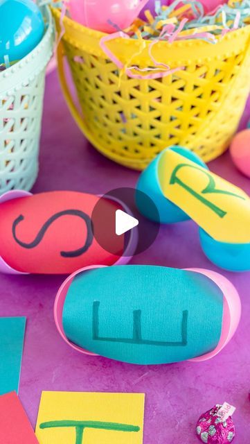 an easter basket with eggs and paper cutouts on it, next to some candy