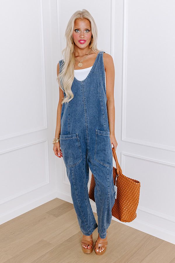 - Show off your trendy style with this cute jumpsuit! It is the perfect piece for a casual look that has that wow factor you have been looking for. - Unlined non-stretch denim material - Straps that lace through a silver colored buckle for adjustable length - A scoop back - Functional back pockets - A relaxed silhouette that ends in straight hemlines Relaxed Fit Overalls For A Day Out, Casual Denim Jumpsuit For Workwear, Chic Medium Wash Cotton Denim Jumpsuit, Casual Medium Wash Denim Jumpsuit For Work, Casual Denim Overall Jumpsuit For Work, Medium Wash Overall Jumpsuit For Day Out, Medium Wash Overall Jumpsuits And Rompers For Day Out, Casual Denim Blue Jumpsuit For Work, Trendy Relaxed Fit Overalls For Day Out