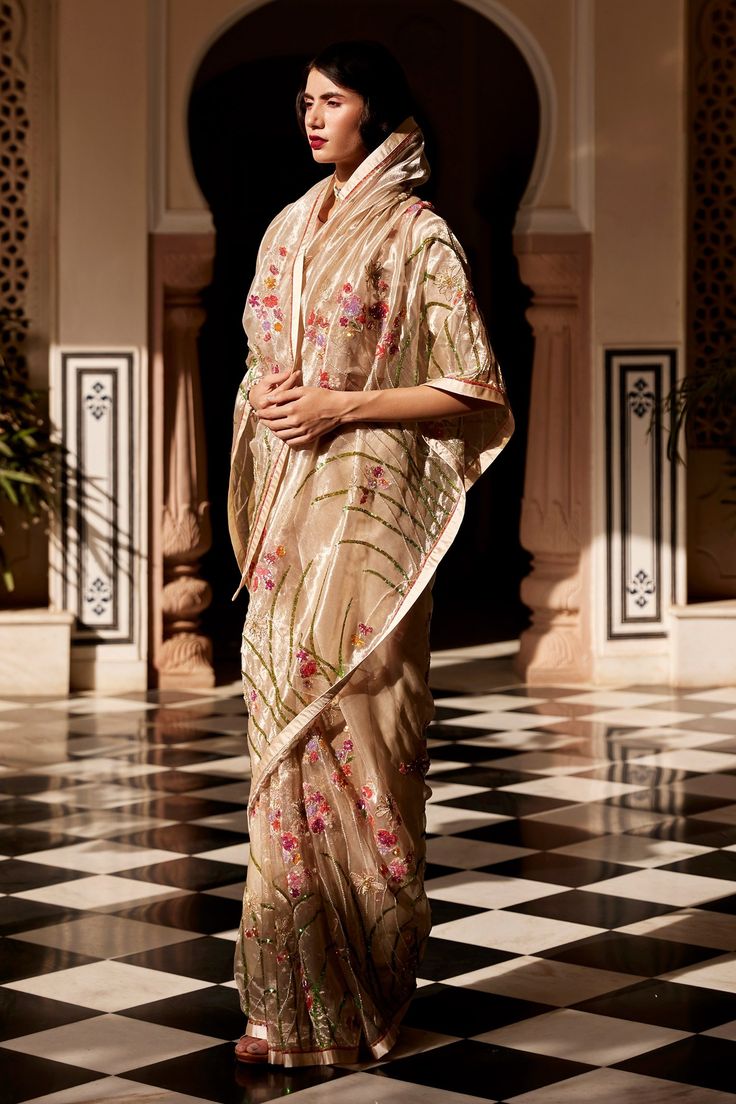 Silver saree in tissue fabric base embroidered with floral, bees in shell sequin motifs. Comes with unstitched blouse.
Components:2
Pattern:Embroidery
Type of Work:Floral, bees, shell sequin
Fabric:Saree - Tissue,  Blouse - Plain Satin
Color:Silver
Other Details:
Swarovski and cut beads motifs
Note: Blouse worn by the model is not for sale
Occasion:Destination Wedding - Aza Fashions Silver Saree, Tissue Fabric, Floral Saree, Dresses Traditional, Saree Designs Party Wear, Cape Style, Indian Dresses Traditional, Embroidered Saree, Plain Blouse