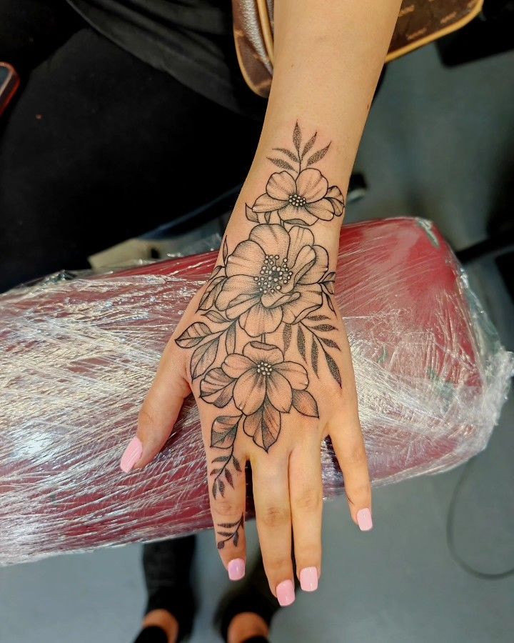 a woman's hand with flowers on it