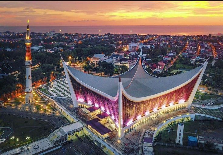 an aerial view of a large building with lights on it's sides at night