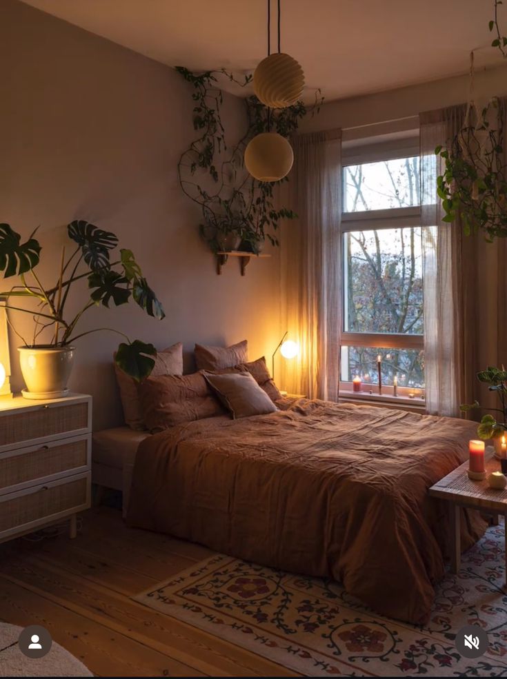 a bed room with a neatly made bed next to a window and some plants on the wall