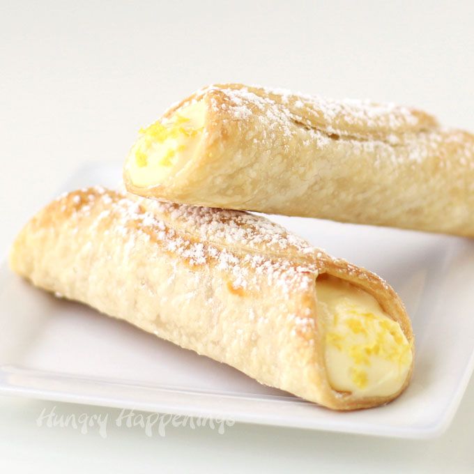 two pastries on a white plate with powdered sugar