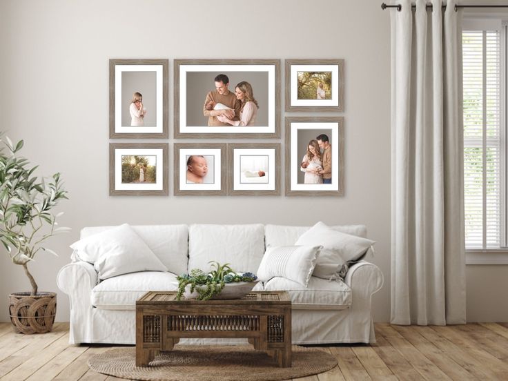 a living room filled with white furniture and pictures on the wall above it's coffee table