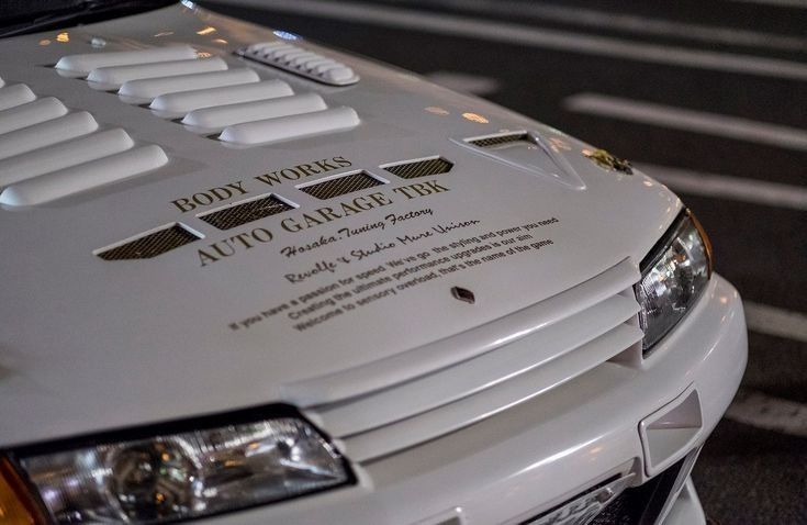 a white car with gold lettering on the hood